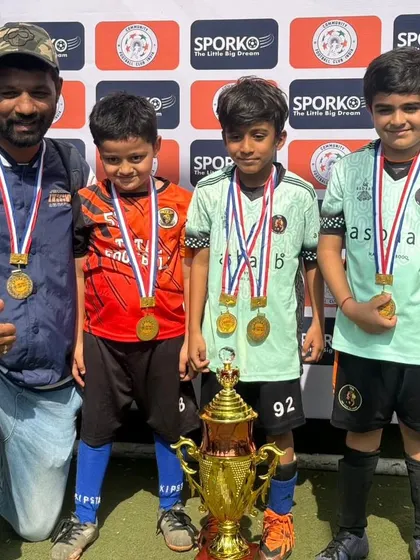 A coach and young players from our U7 and U11 teams with their Republic Cup 2024 trophy.