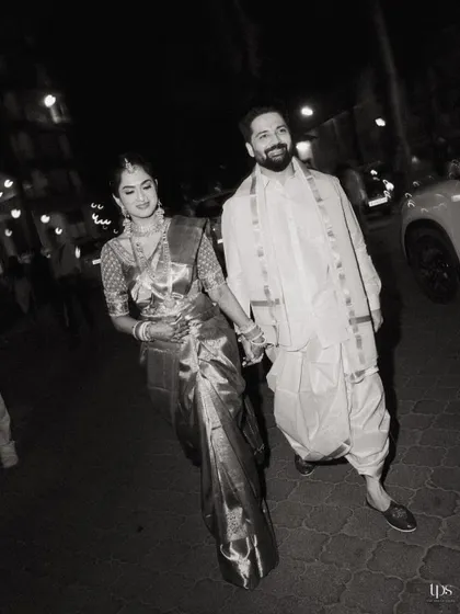 A candid, black and white shot of the couple walking hand-in-hand at night. This photo has a classic, cinematic feel, capturing a quiet moment amidst the celebrations.