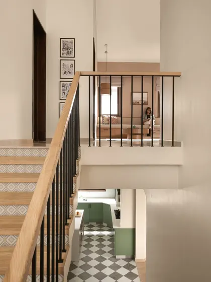 A view from the top of the stairs looking down into the kitchen and up towards a lounge area. This shot captures the multi-level design and the open, connected feel of the home.