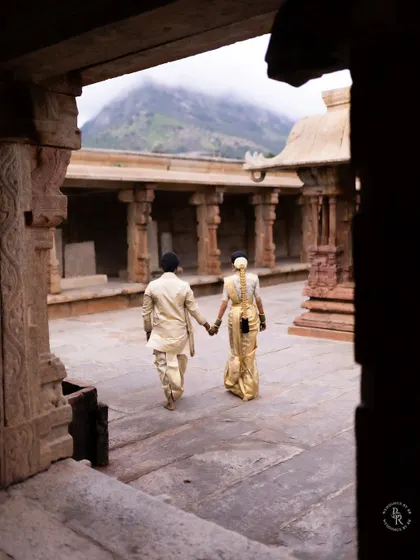 The couple walks hand-in-hand through a historic temple corridor, a symbolic start to their new life together.
