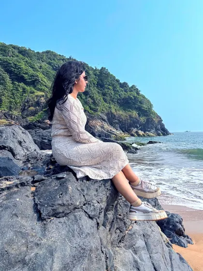 A trekker sits on the rocks, gazing out at the serene ocean during our Gokarna beach trek.
