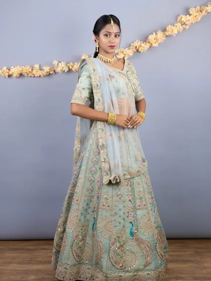 A full-length view of the mint green lehenga, adorned with stunning peacock motifs and multi-color threadwork. This is a truly artistic and traditional piece.