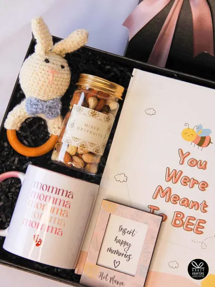 "You were meant to BEE." A sweet bee-themed hamper for a mom-to-be, including a 'Momma' mug, a baby book, a crochet rattle, and healthy dry fruits.