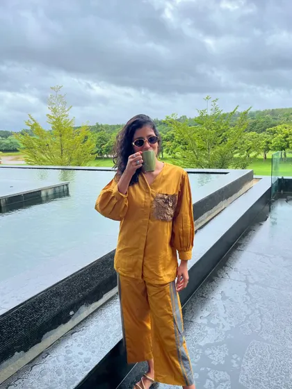 Enjoying a cup of coffee with a view. This mustard co-ord set is a comfortable and stylish choice for a relaxed morning on vacation.