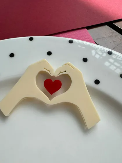A modern and sweet Valentine's charm showing two hands forming a heart. This is a lovely, subtle way to add a touch of love to your treats.