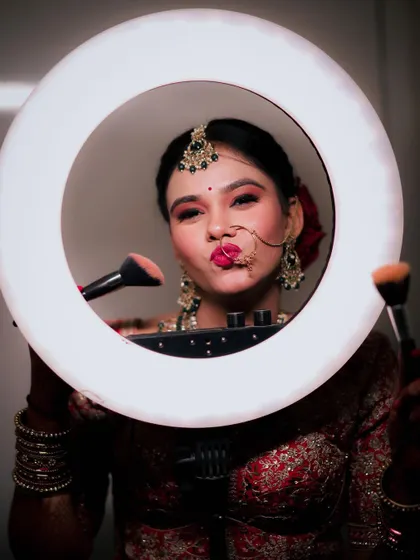 A fun and confident bridal portrait, with the bride making a playful expression while posing inside a ring light. This shot shows her vibrant personality.