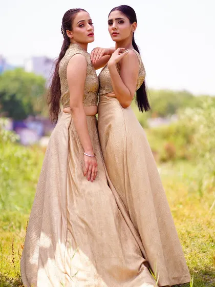 A slightly different angle of the two models, showcasing their connection and the beautiful texture of their matching outfits. This shot is perfect for a lookbook emphasizing friendship or sisterly bonds.