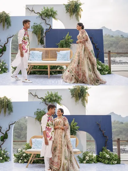 The couple at their riverside Mehendi. The backdrop was designed with modern, arched panels in shades of blue, adorned with wild, organic greenery to mimic the surrounding nature.