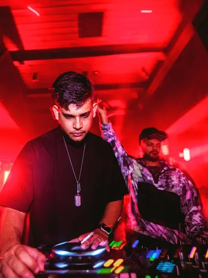 Focused on the mix while my partner DJs in the background. Collaboration is key to a great night.