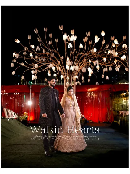 'Walkin Hearts'. The couple walks through their beautifully lit outdoor reception venue, creating a magical atmosphere.