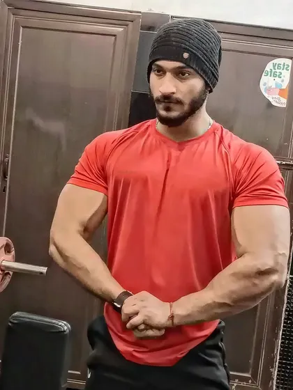 A strong pose in a red t-shirt and beanie.