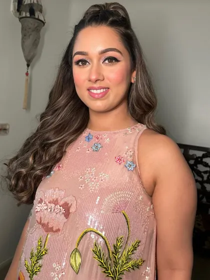 A close-up of the glistening pink makeup, highlighting the shimmery eye and the radiant skin.