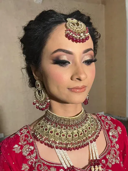 This side profile highlights the winged eyeliner and the intricate hairstyle. Every element is carefully crafted to create a cohesive and stunning bridal look.
