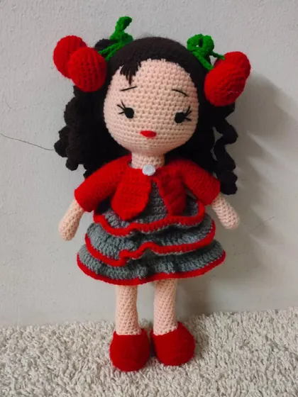 A closer look at the doll with the cute cherry hair clips and a layered dress.