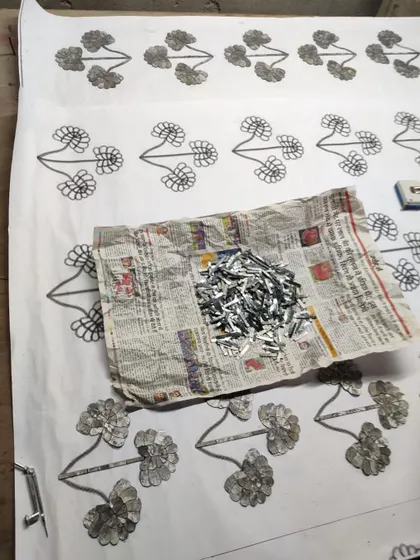 The process of creating Thikri involves sketching the design and then carefully arranging tiny, hand-cut pieces of mirrored glass. Here, the glass pieces are ready to be set.