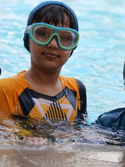 Our swim classes are a great place to make new friends. Here, a group of young swimmers waits for their turn, ready to cheer each other on.