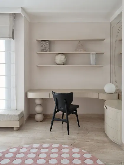 A wider shot of the study area, showing the clean lines of the desk and the elegant black chair. The space is designed to be both inspiring and functional, with ample natural light.