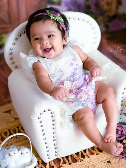 A girl like a pearl. This three-month-old's happy smile and beautiful floral outfit make for a truly precious portrait.