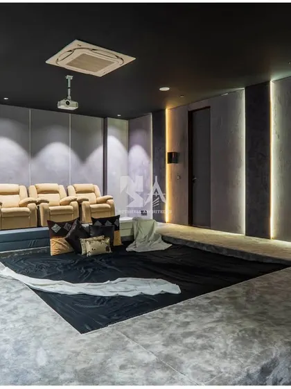 We create bespoke entertainment spaces that are both stylish and functional. This home theater is designed with tiered, dug-out seating in micro-concrete for a cozy, immersive feel, complemented by plush leather recliners. The acoustic wall paneling and integrated lighting ensure a premium cinematic experience right at home.