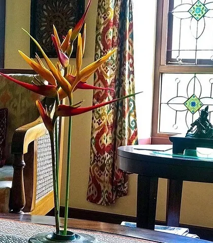 A detail shot from the Roopa Hariprasad Residence shows how we layer textures and patterns. The vibrant floral arrangement, patterned curtains, and decorative window grille come together to create a visually rich interior.