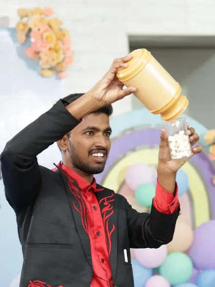 A classic stage magic moment during a birthday celebration. I love performing production illusions like this one, where I make endless popcorn appear from a seemingly empty container.