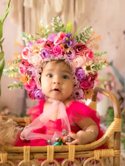An inquisitive look from the baby during her floral half-birthday session, showing her personality.