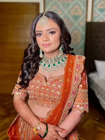 A close-up portrait showcasing the soft eye makeup and the beautiful contrast with the emerald jewelry.