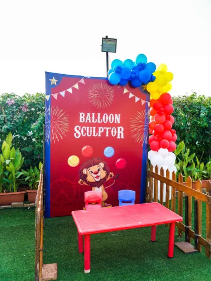 A balloon sculptor station set up at an outdoor circus party, where our artist creates amazing animals and shapes for the children.