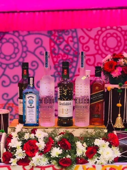 Let's bring the vibrant energy of Punjab to your celebration with a 'Funjabi' themed bar. This setup features premium spirits displayed amidst traditional dhols and bright floral arrangements, perfect for a high-energy Haldi or Mehendi ceremony.