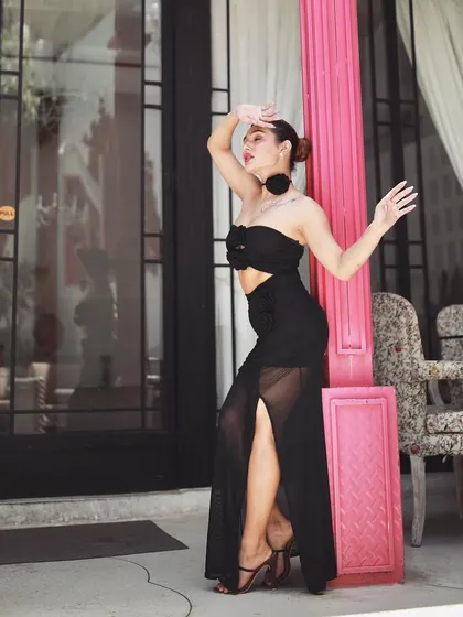 A high-fashion pose from the same series, showcasing the model's silhouette and the sheer details of the black dress.