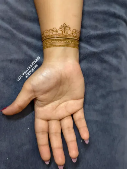 The back of the hand showing a simple yet elegant wristband design, a perfect complement to a heavy bridal front-hand design.