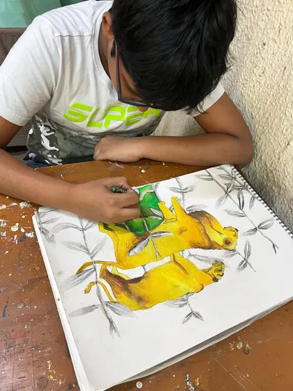 A young artist using oil pastels to create a powerful drawing of lions, learning about animal anatomy and color blending.