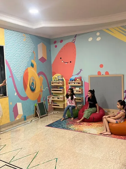 A wide view of our reading room during the story session. You can see our colorful mural and the cozy beanbags where kids love to sit.