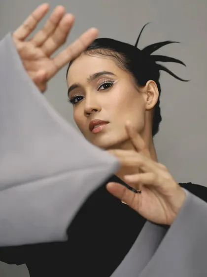 A beautiful pose that frames the face and highlights the clean, sharp line of the white eyeliner.