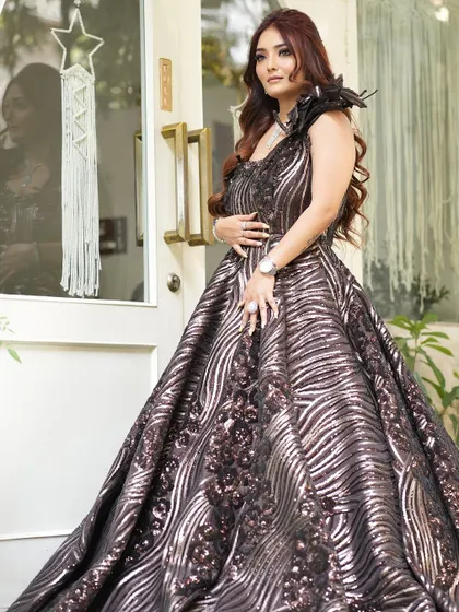 A full-length shot of a client ready for a grand event. The soft glam makeup perfectly complements her dramatic, sequined gown.