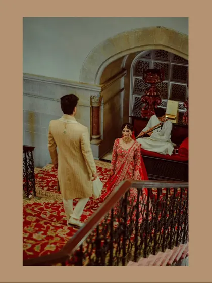 An artistic shot of the couple on a grand staircase, with a musician playing in the background, adding to the romantic ambiance.