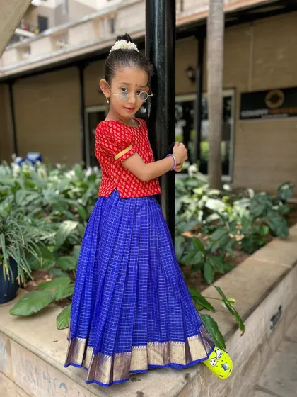 Posing with confidence. This full-body shot shows off her beautiful traditional outfit, blending cultural pride with a playful attitude.