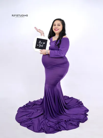 Announcing a baby girl! We love incorporating gender reveal props into our sessions. The mom-to-be looks radiant in a purple gown while holding a sign celebrating the upcoming arrival of her daughter.