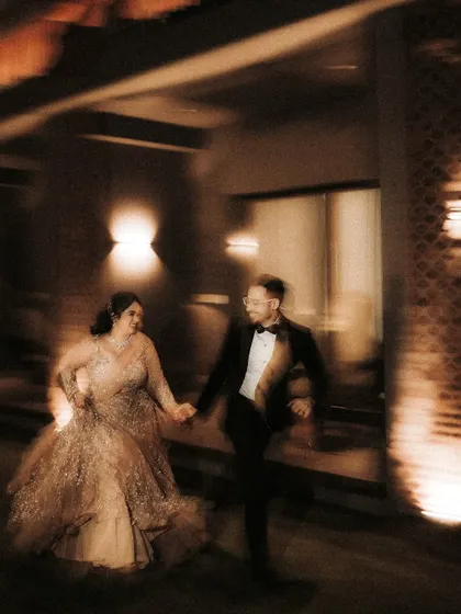 A dynamic, motion-blurred photo of the couple walking hand-in-hand. The effect captures the energy and excitement of their reception night in a creative and artistic way.