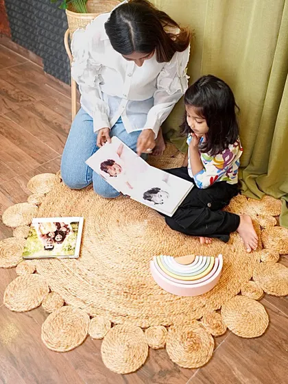 Looking at photo albums on our natural jute rug. Creating a comfortable and beautiful floor space encourages these quiet, bonding activities.