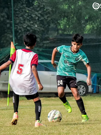 A player skillfully maneuvers the ball past a defender.