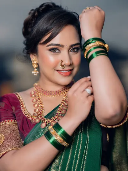 A stunning Marathi beauty. This look features defined, smokey eyes and a warm, glowing complexion, perfectly paired with the traditional Maharashtrian nose ring and green bangles.