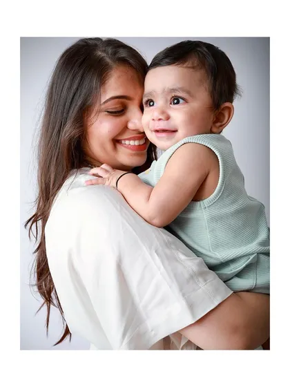 A heartwarming photo of a mother holding her smiling baby.