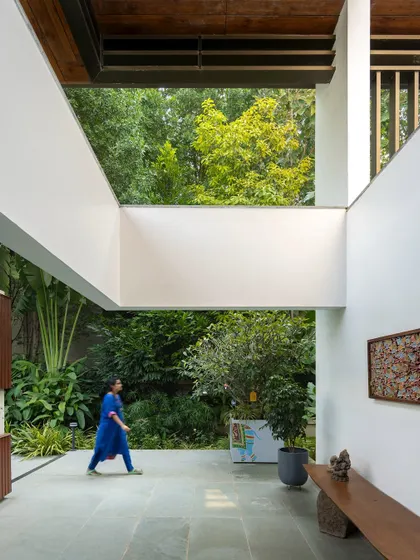 A walkway in a modern home that feels like a stroll through a garden. With open sky-lights and views of the lush exterior on both sides, the architecture is designed to constantly engage with the landscape.
