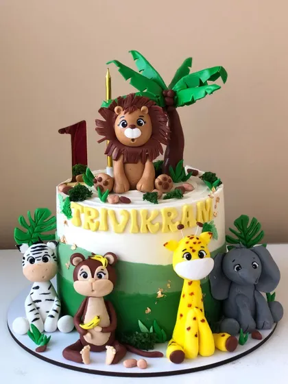 Another take on a jungle safari cake, with a variety of handcrafted animals and a golden name plaque.