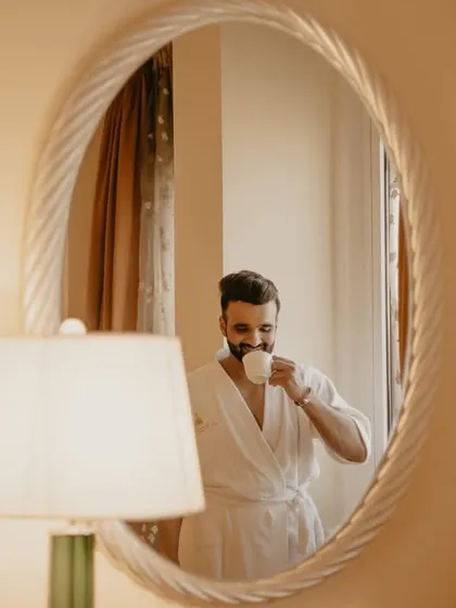 A reflection of the groom in a mirror, a creative portrait taken during the getting-ready process.