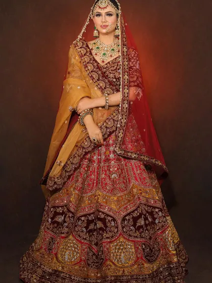 A full view of the bride in her magnificent red and gold lehenga. Our makeup ensures the bride looks stunning from every angle, tying the entire look together.
