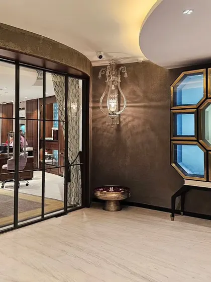 The waiting and reception area at KR Sons is designed to prioritize customer comfort. An octagonal display cabinet and an ornate wall sconce create a luxurious focal point, allowing guests to relax in an inviting atmosphere before their consultation.