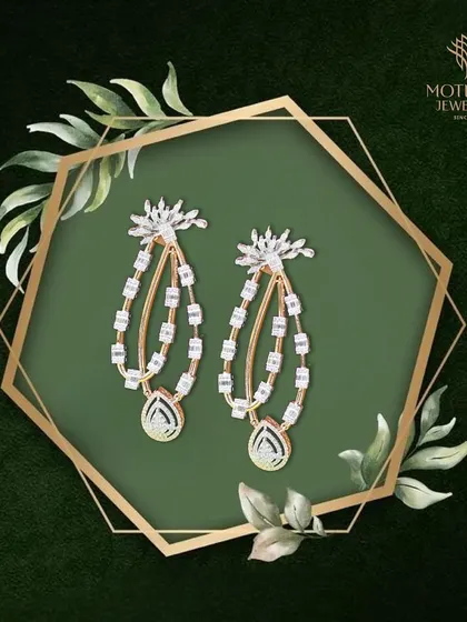 A pair of elegant, dangling earrings with a modern, artistic design. The combination of baguette and pear-shaped diamonds creates a sense of movement and sophisticated sparkle.
