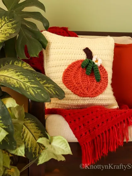 The pumpkin cushion paired with a cozy red throw, creating the perfect autumn vignette on the sofa.